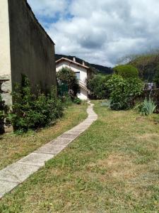 un sentiero in pietra nell'erba vicino a un edificio di Les chambres du Montagut a Saint-Sauveur-de-Montagut