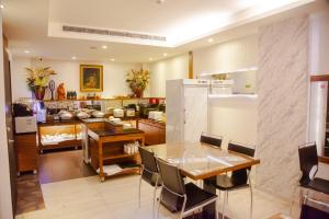 E-Coast Star Hotel في كيلونغ: مطبخ وغرفة طعام مع طاولة وثلاجة