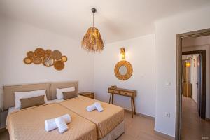 a bedroom with a bed with towels on it at Manolia View Mykonos in Tourlos
