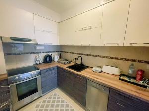 - une cuisine avec des placards blancs et un évier dans l'établissement SoleMare Apartment, à Budva