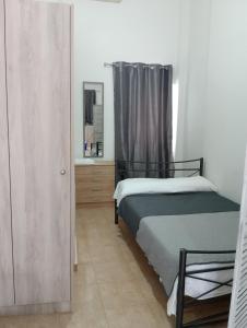 a bedroom with two beds and a mirror at Studio Jim in Volos
