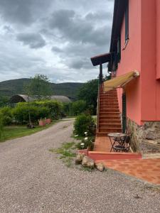 a red building with a table and a bench next to it at Maremma Toscana Podere Poggiarelli in Campagnatico