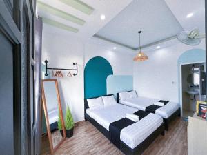 a bedroom with two beds and a mirror at Mon-Min Hotel in Da Lat