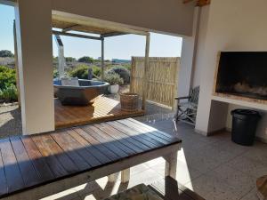 a bathroom with a bath tub on a patio at Camelot Cottages in Langebaan