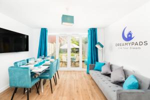 a dining room with a table and blue chairs at Spacious Group House for Contractors & Families - Ensuites, Parking & Netflix by DreamyPads in Bristol
