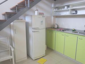 a kitchen with a white refrigerator and green cabinets at Moderno y cómodo duplex en capital de San Juan in San Juan