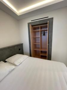 盧貝新城的住宿－06AO - Superbe appartement avec vue mer exceptionnelle，卧室配有白色的床和衣柜。