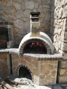 een stenen pizzaoven in een stenen muur bij Dioni Villa in Sivota