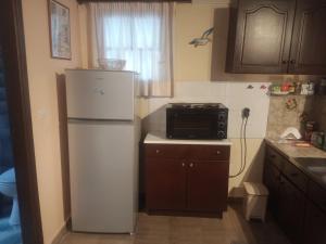 a kitchen with a white refrigerator and a stove at Studio Nausica... a sense of paradise! in Agia Pelagia Chlomou