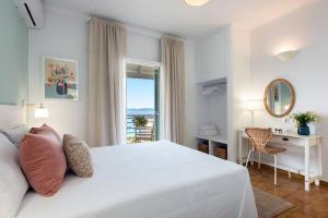 Schlafzimmer mit einem Bett, einem Schreibtisch und einem Fenster in der Unterkunft Reana Elegant Apartments in Barbati