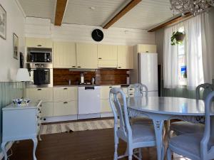 a kitchen with a table and chairs and a refrigerator at Krepelin Apartments in Kristinestad