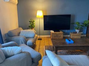 a living room with couches and a flat screen tv at Krepelin Apartments in Kristiinankaupunki