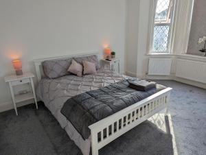 a bedroom with a white bed with two night stands at Cosy Bee in Bournemouth