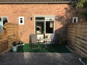 a patio with a table and chairs and a brick wall at t Schooltje in Schoondijke