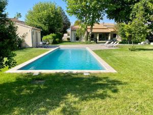 een zwembad in de tuin van een huis bij Le chant des jardins in LʼIsle-sur-la-Sorgue
