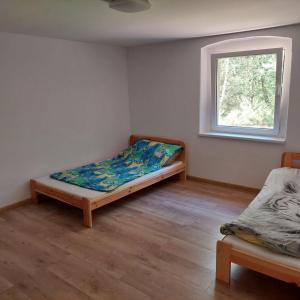 a small room with a bed and a window at Dom wypoczynkowy w lesie nieopodal jeziora in Szteklin
