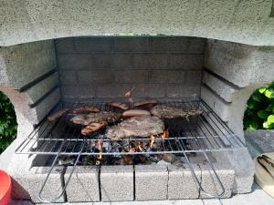 een grill met vlees en ander voedsel koken op het bij A Due Passi dal Lago in Colico