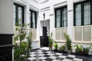 Biały dom z czarnymi oknami i szachownicą w obiekcie San Buenaventura Apartment 1 w Sewilli