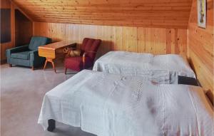 um quarto com 2 camas, uma cadeira e uma mesa em Lovely Apartment In lvdalen With Kitchen em Älvdalen