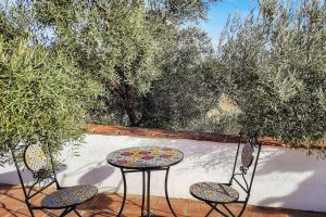 a patio with two chairs and a table and a table and two chairs at Gusta la Vista in Ríogordo