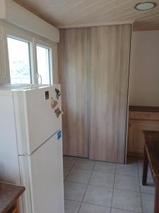 a kitchen with a white refrigerator and wooden cabinets at La Vinsonne in Glun