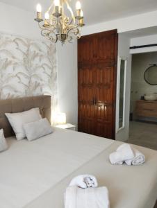 a bedroom with a large white bed with towels on it at Villa Costera B&B in Sant Antoni de Calonge