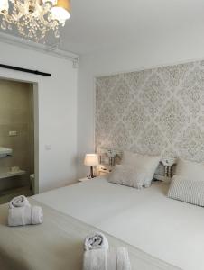 a bedroom with a large white bed with towels on it at Villa Costera B&B in Sant Antoni de Calonge