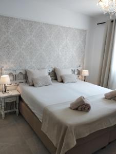 a bedroom with a large white bed with two lamps at Villa Costera B&B in Sant Antoni de Calonge