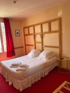 a bedroom with a large bed with two towels on it at Hôtel La Capitainerie in Châteauneuf-sur-Loire