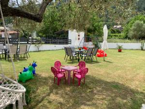 a table and chairs in a yard with a playground at Harmony Studios & Apartments in Skala Potamias