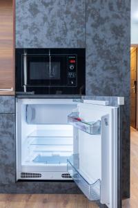 an open refrigerator with a microwave on top of it at View apartment #1 in Bansko