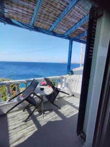 balkon z 2 krzesłami i widokiem na ocean w obiekcie Marisini Sea View w mieście Batsi