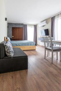 a bedroom with a bed and a couch and a table at View apartment #1 in Bansko