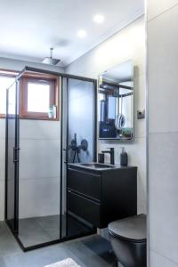 ein Bad mit einem schwarzen Waschbecken und einem WC in der Unterkunft View apartment #1 in Bansko