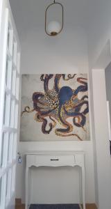 a painting of an octopus on a wall above a white desk at Octopus Suites Parikia in Parikia
