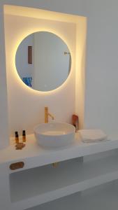 a white bathroom with a sink and a mirror at Octopus Suites Parikia in Parikia