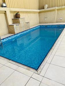 a large blue swimming pool in a house at Happy Day هابي دي 