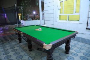 a green pool table sitting in front of a house at Happy Day هابي دي 