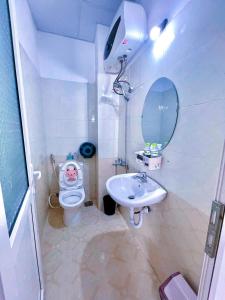 a bathroom with a toilet and a sink and a mirror at Mon-Min Hotel in Da Lat