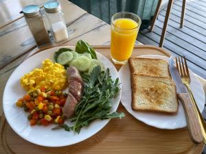 a plate of breakfast food with eggs sausage vegetables and toast at СвояХата in Svityazʼ