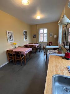 Sejerø Vandrehjem في Sejerby: مطبخ وغرفة طعام مع طاولات وكراسي