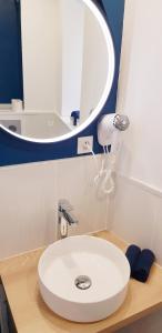 y baño con lavabo blanco y espejo. en Escapade Niortaise - Studios climatisés hyper-centre de Niort, en Niort