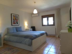 a bedroom with a bed with blue sheets and a window at Villa Senomar in Benissa