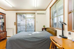 um quarto com uma cama e uma secretária com um candeeiro em Sakai Kita-ku - House - Vacation STAY 10593 em Asakayamachō