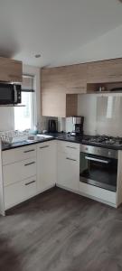 a kitchen with white cabinets and a stove top oven at La Carabasse in Vias