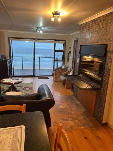 uma sala de estar com lareira e vista para o oceano em Makarios em Groot Brak Rivier