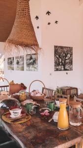 a wooden table with plates and bowls and a vase at The Blue House Valley in Grândola