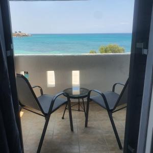 - un balcon avec deux chaises et une table donnant sur l'océan dans l'établissement Verykokkos on the beach, à Agia Anna