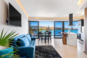 a living room with a blue couch and a view of the ocean at Tizate Residences #136 in Cruz de Huanacaxtle