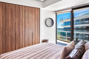 a bedroom with a large wooden closet and a large window at Tizate Residences #136 in Cruz de Huanacaxtle